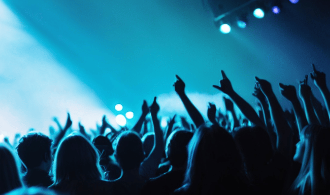 A crowd at a show feeling the emotion of the music