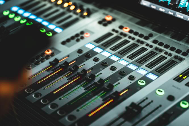 Volume faders of a mixing board in a music studio